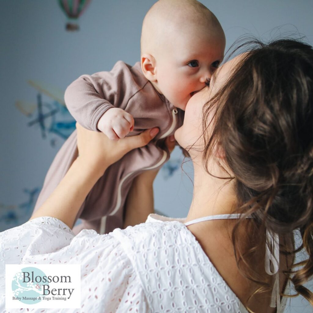 Why Teach Baby Yoga? - picture of a mum holding aloft a baby and snuggling her nose against him