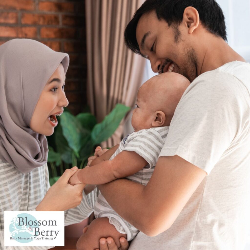 Baby Massage for Motor Development: Benefits, Techniques & Early Movement Support - picture of a mum, dad and baby laughing together