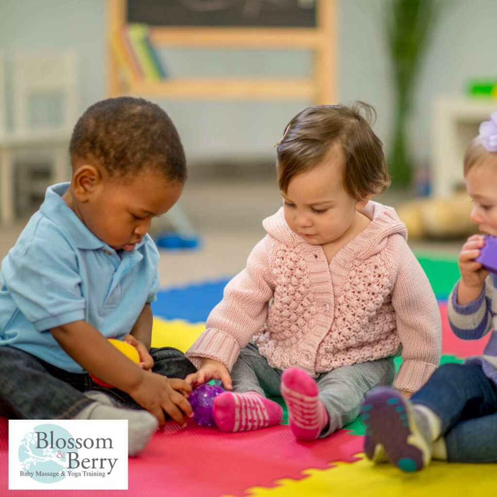 Massage for Toddlers: 10 Playful Techniques & Benefits - picture of 2 toddlers sat on a mat playing with toys