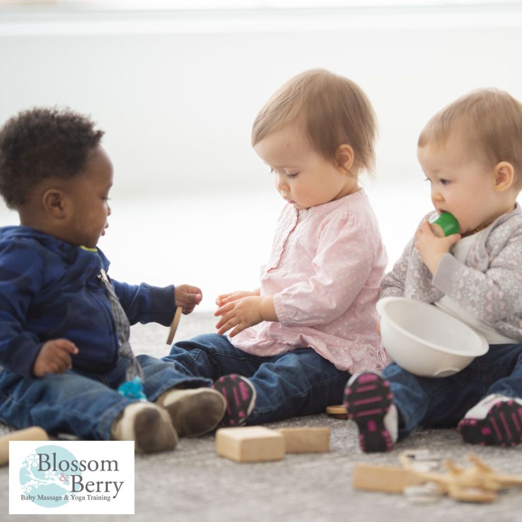 Baby Yoga FAQ: Everything Caregivers Need to Know - picture of three toddlers sitting and playing with blocks on the floor
